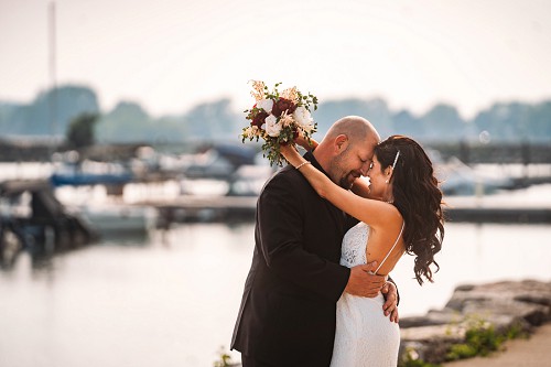 bride and groom in front of boats