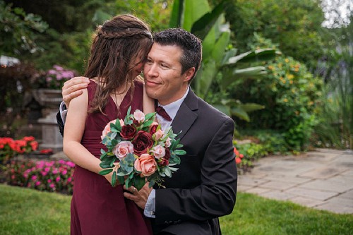 daughter hugging groom at wedding