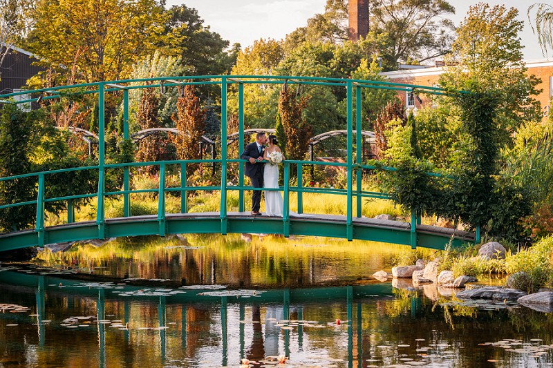 bride and groom on bridge in pillar and post gardens