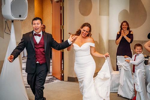 couple entering wedding reception at white oaks