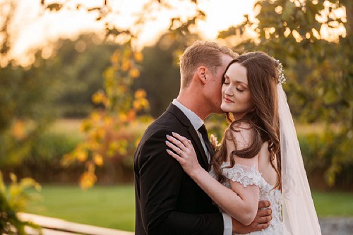 groom whispering in brides ear