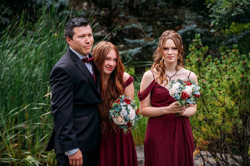 groom and daughters watching bride walk down isle