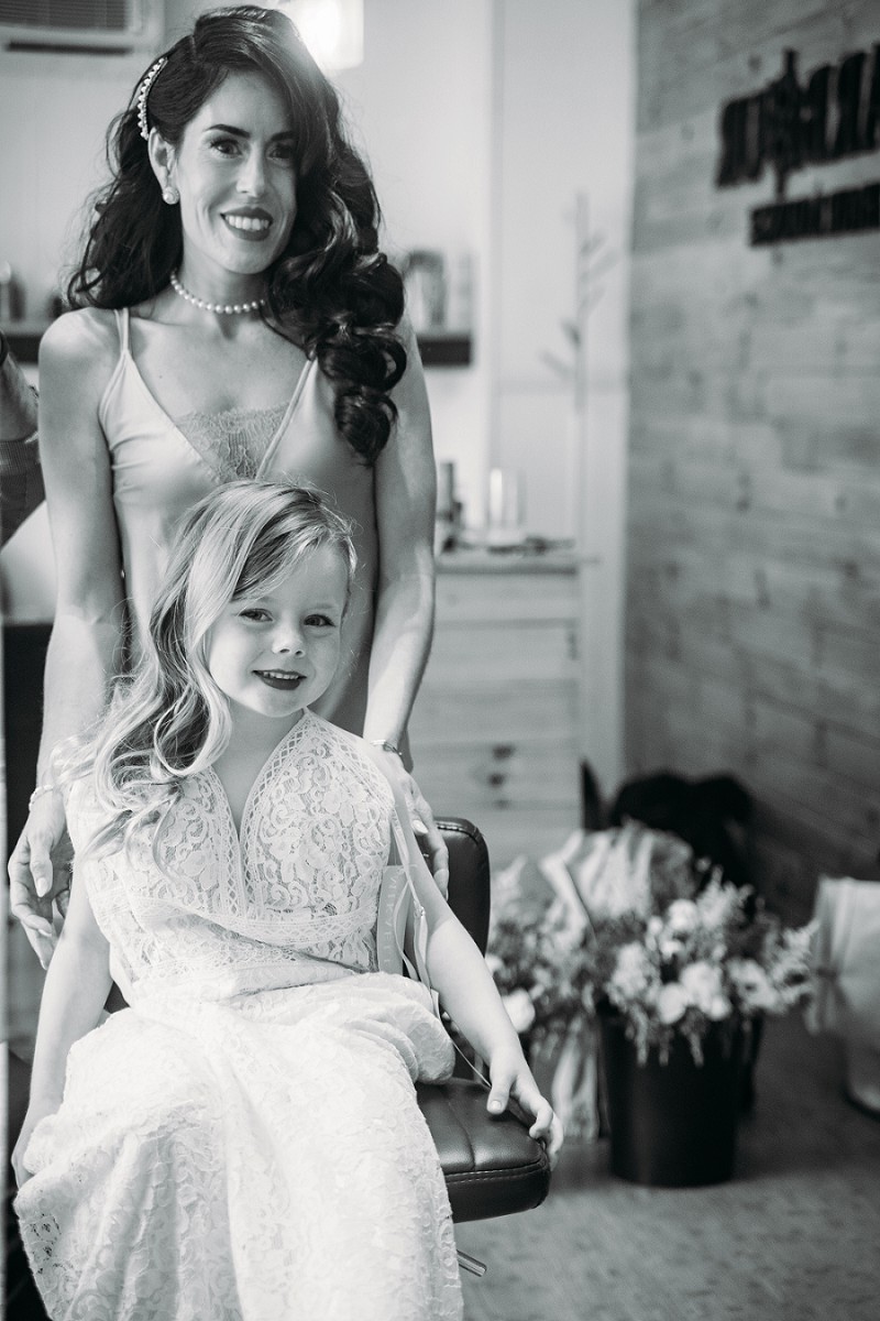 bride looking at daughter in mirror wearing her wedding dress