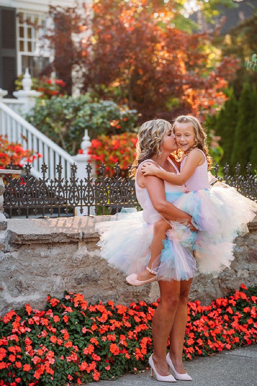 mom holding daughter and kissing her on cheek