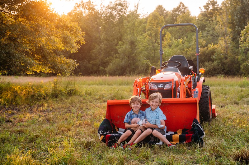 brothers posing on tractor for family picture