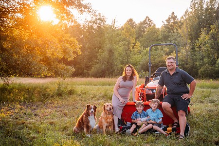 sunset family photo with dogs and tractor