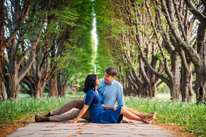 couple sitting on pathway between trees