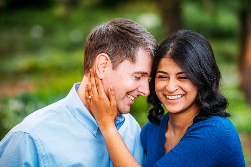 couple laughing while she holds his face