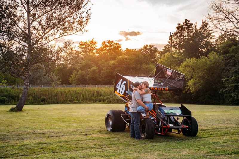 couple sitting on race car