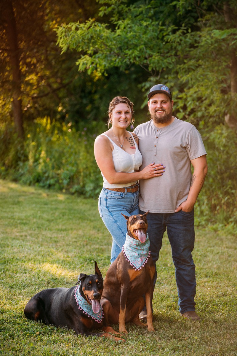 couple smiling at camera with dogs