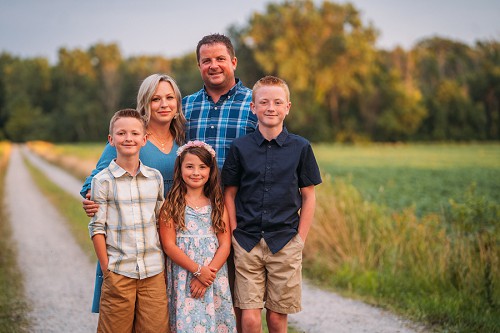 family posing on a farm