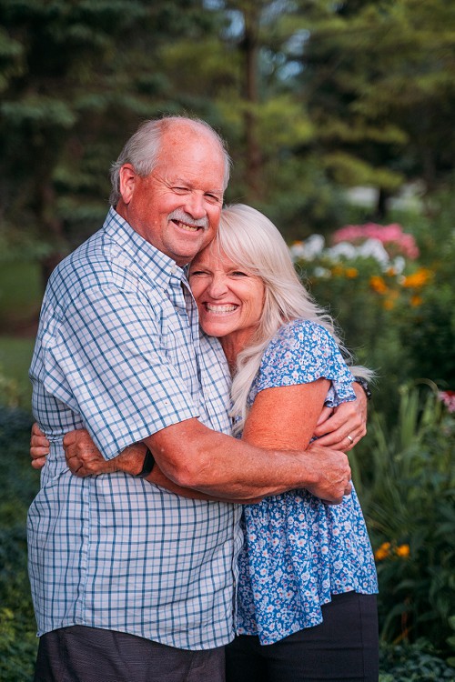 candid of happy grandparents hugging and smiling