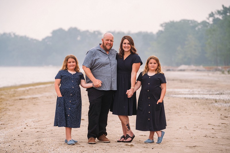 family posing at beach