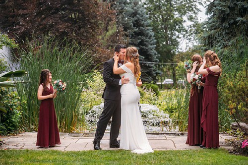 bride and groom kissing while kids hide their faces