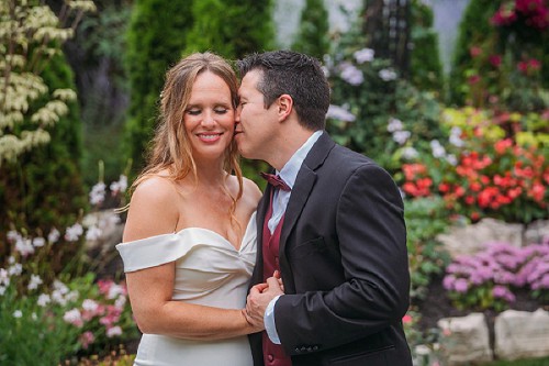 groom kissing bride on cheek