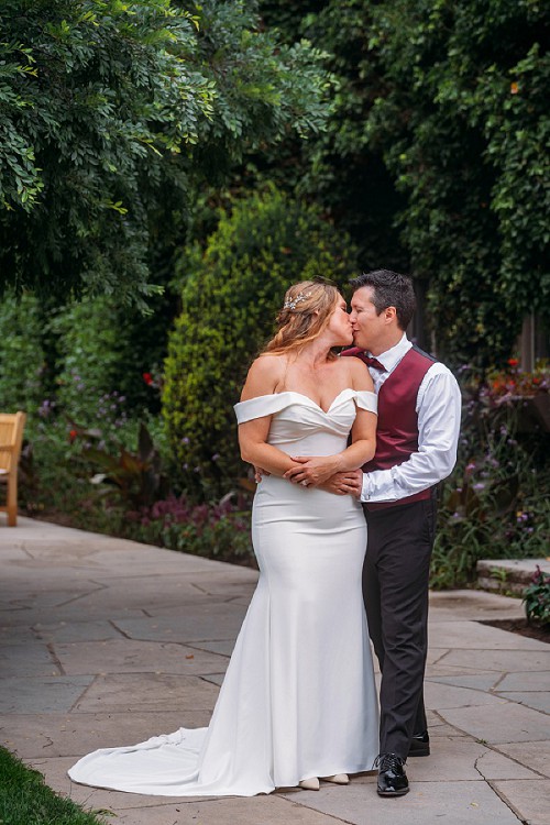 couple holding each other and kissing at botanical gardens