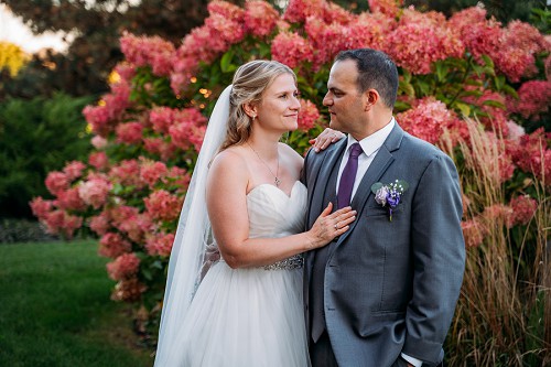 bride and groom in front of flowers