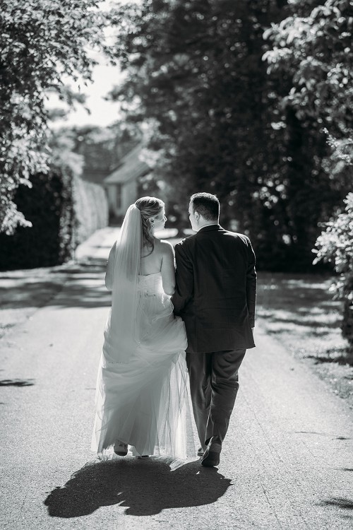 bride and groom walking in black and white