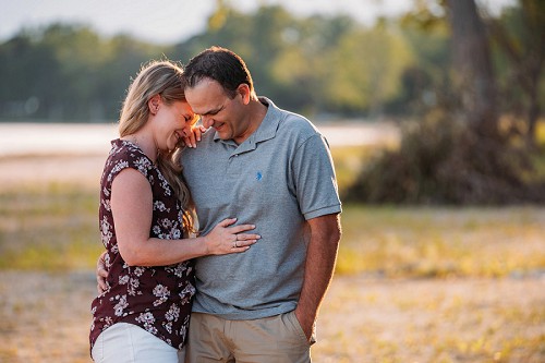Sunset beach engagement with couple laughing