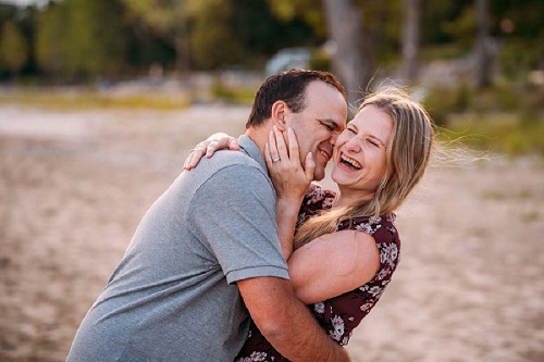 engagement shoot on beach with couple laughing