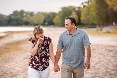 couple laughing and walking on beach