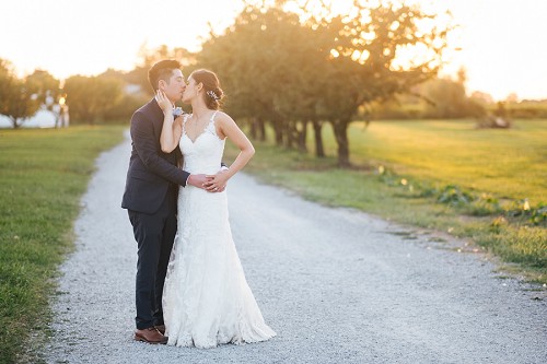 bride and groom kissing at sunset