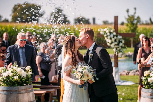 bride and groom walking down aisle with confetti