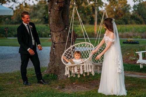 bride and groom playing with flower girl