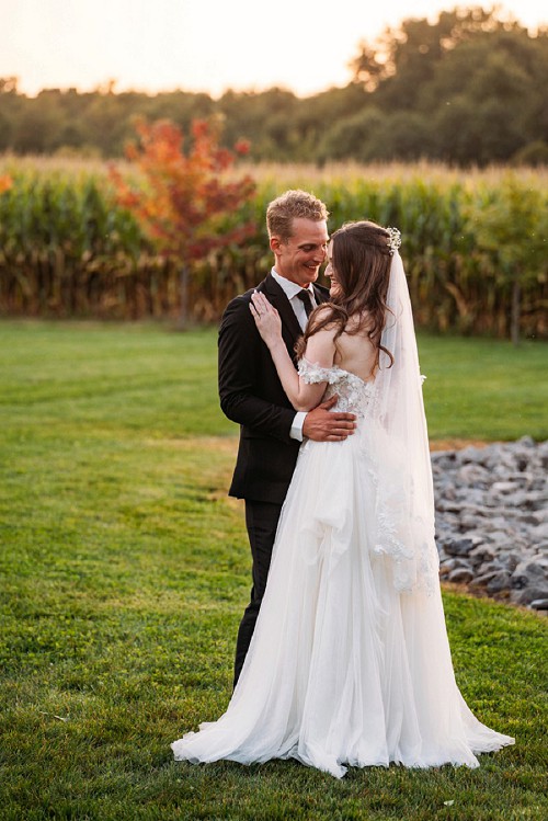 bride in her dress from behind with groom holding her