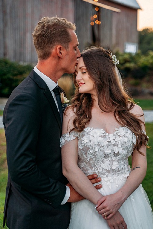 groom kissing bride on forehead