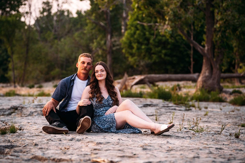 engagement pic with couple sitting on beach