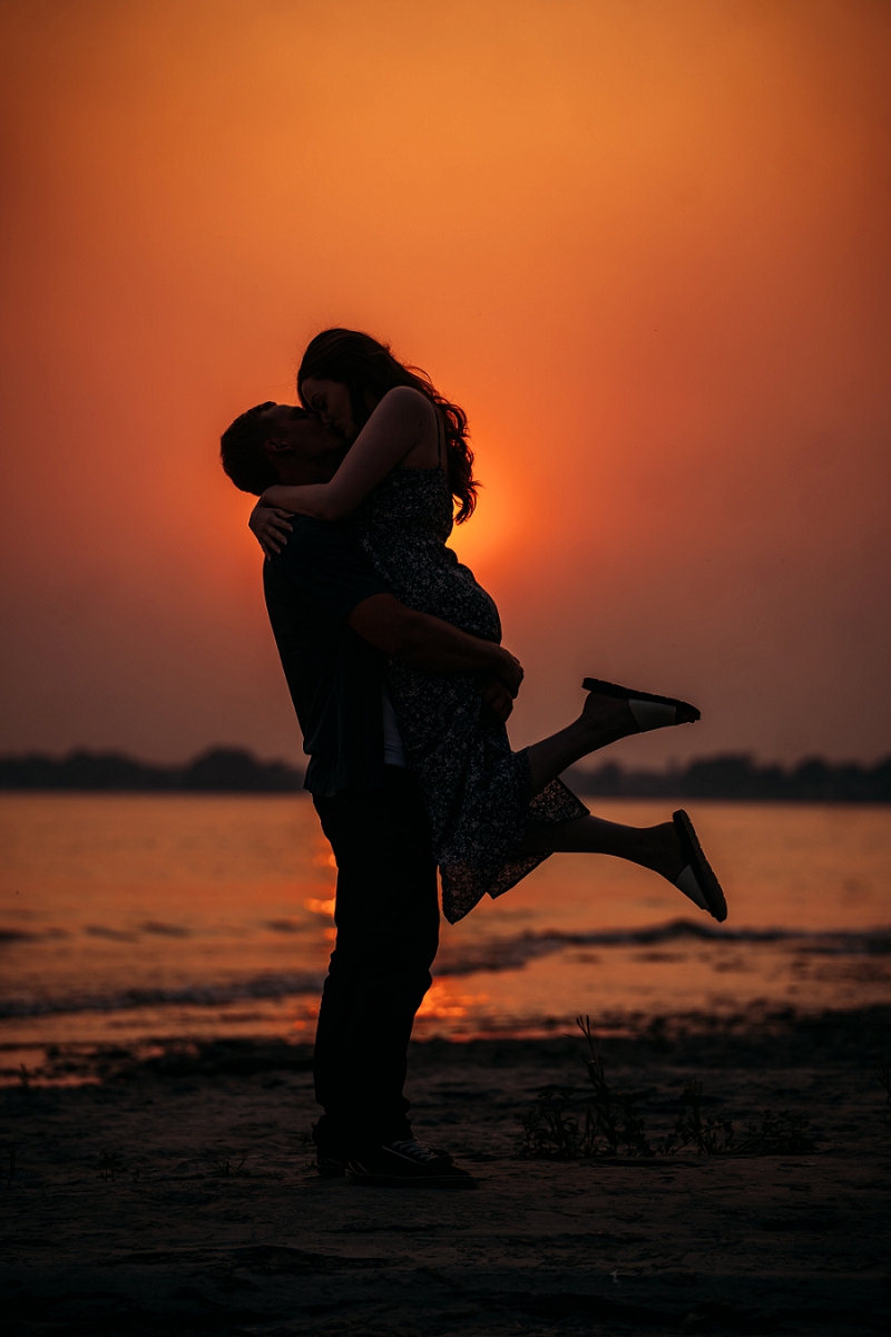 beach silhouette at sunset with ontario wildfires making sky orange