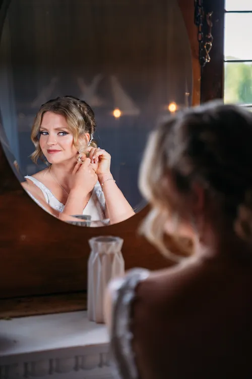 Portrait of Bride looking in mirror at the Loft at Maple Meadows Farm
