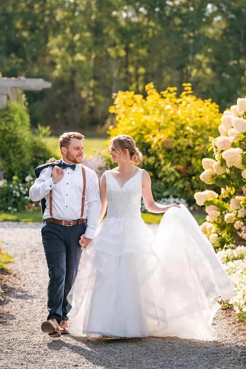 Bride and groom walking along pathway at Maple Meadows
