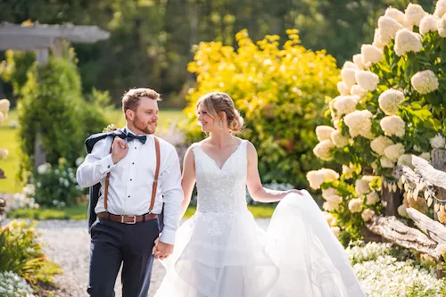 Bride and groom walking and laughing at Maple Meadows Farm in Port Colborne