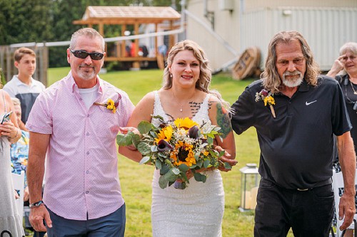 bride walking with dads