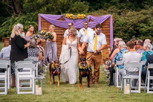 bride and groom walking down isle with their dogs