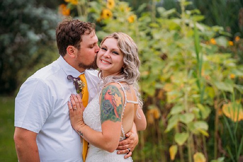 groom kissing bride on cheek