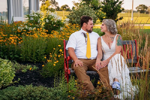 bride and groom sitting on bench