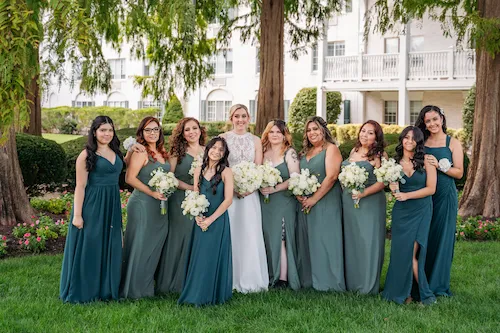 bride with bridesmaids and flower girl smiling