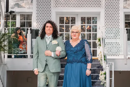 groom walking down aisle with mom