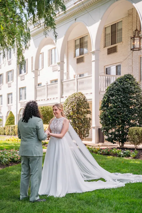 Bride and groom holding hands in front of The Madison Hotel in Morristown, NJ
