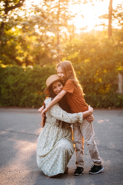 son hugging mom at sunset