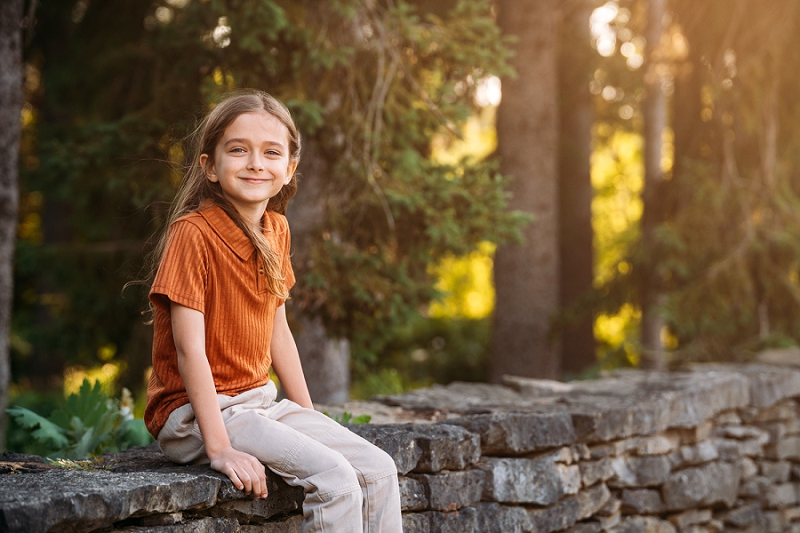 child portrait sitting on rock wall