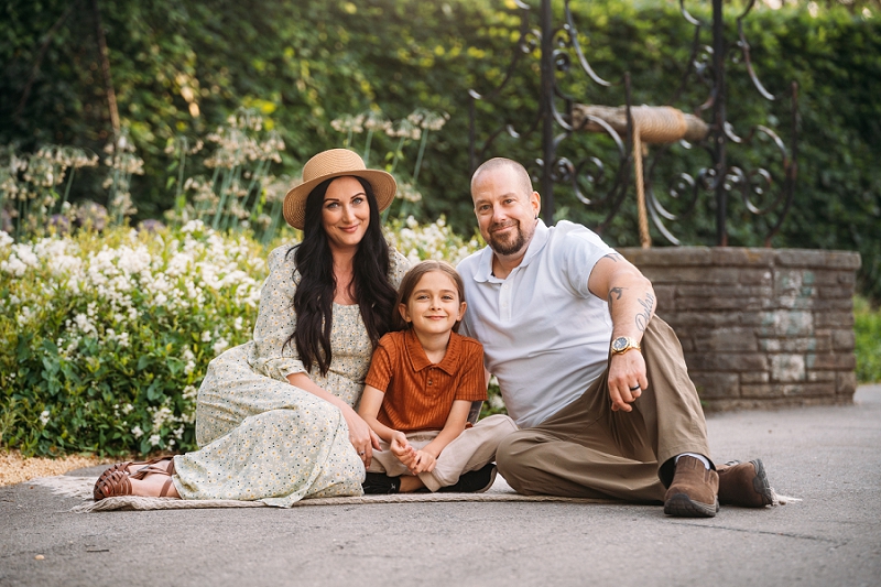 family portrait sitting down in front of flowers