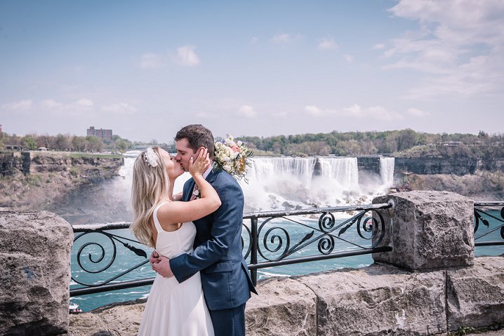 bride and groom kissing in front of niagara falls