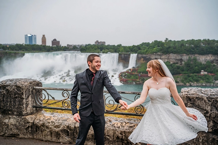 bride and groom dancing in front of niagara falls